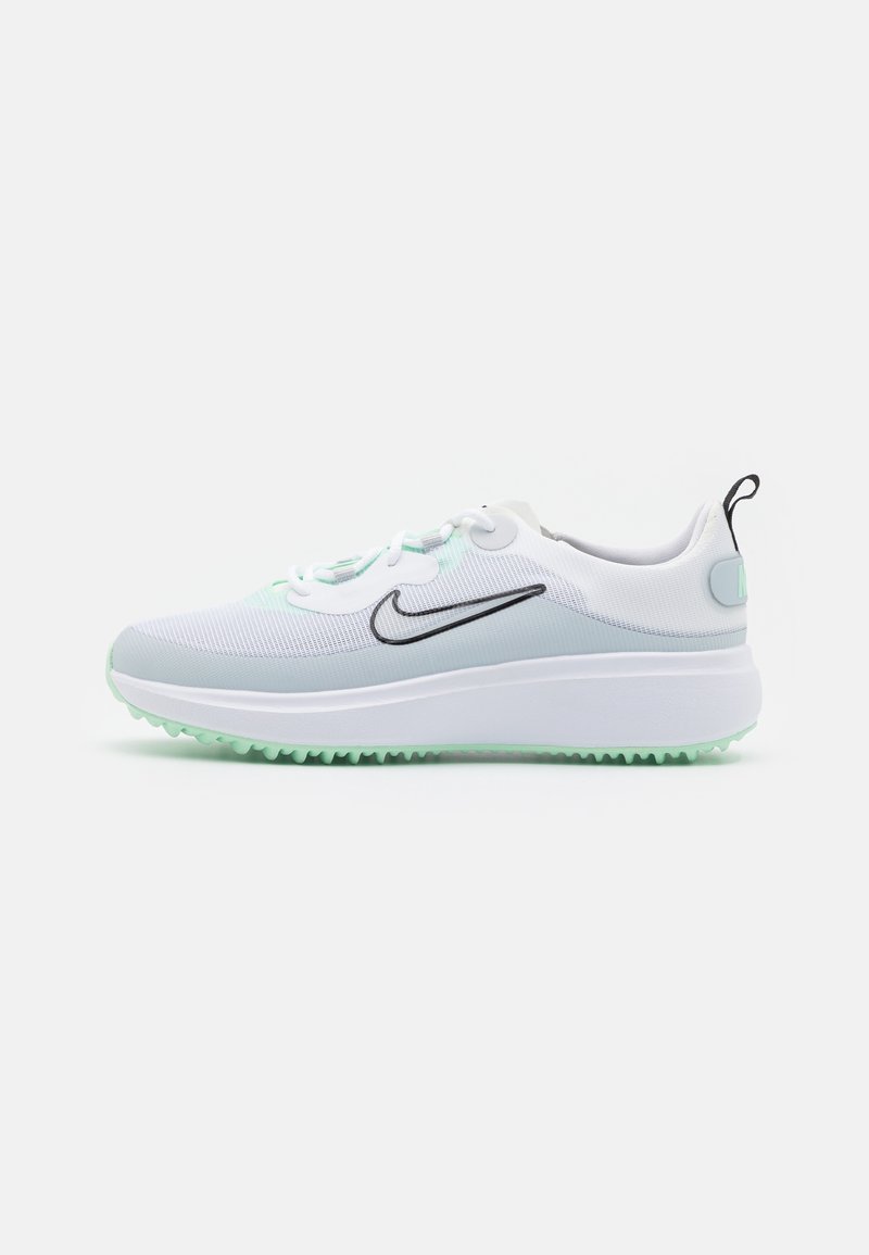 Baskets Nike blanches et gris clair avec un logo swoosh noir, fermeture à lacets, semelle épaisse et semelle extérieure texturée vert clair.