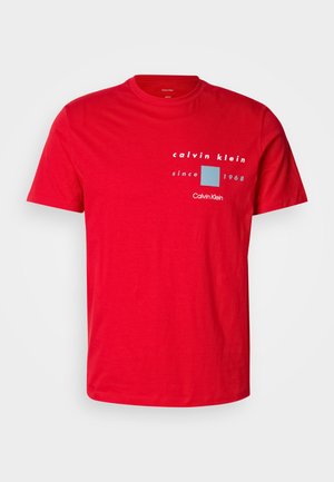 Rode katoenen t-shirt met een ronde hals, korte mouwen, en een gedrukt logo ontwerp in wit en blauw, met de tekst "sinds 1968".