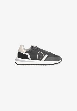 Männlicher niedriger Sneaker in Schwarz, Grau, Weiß und Beige mit Schnürung vorne und schildförmigem Logo an der Seite.