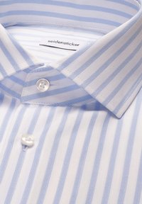 Chemise blanche à rayures verticales bleu clair, col boutonné, avec étiquette de marque visible "seidensticker" à l'intérieur du col.