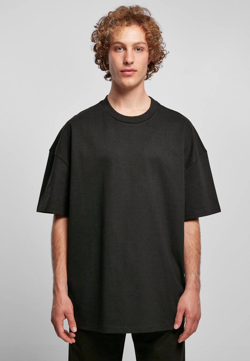 Zwart oversized t-shirt van katoen, met een ronde halslijn en korte mouwen, een gladde textuur en minimale stikseldetails.