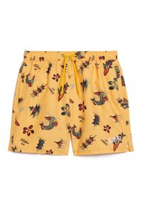 Pantaloni da bagno gialli con una varietà di motivi tropicali colorati, tra cui draghi, motivi floreali e pagode. Vita elastica con cordoncino.