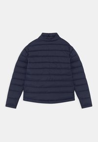 Mørkeblå quiltet jakke med horisontal quiltedesign, høj krave og lange ærmer. Glat tekstur med en normal pasform.