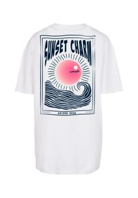 T-shirt bianca con una stampa grafica sul retro che presenta un sole rosa, onde e testo blu che dice "SUNSET CHARM."