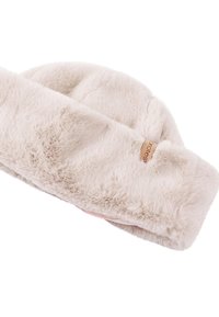 Cream-colored soft faux fur headband with a small brown brand tag on the side, laid flat on a white background.