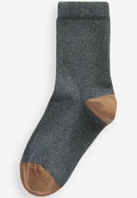 Chaussette gris foncé en tissu doux et texturé. Présente une accent beige au niveau des orteils et du talon. Design classique de longueur mi-mollet.
