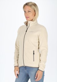 Beige fleecejack met hoge kraag, rits aan de voorkant en grijze accenten. Voorzien van een zijzak met rits en een gladde textuur. Ideaal voor het dragen in lagen.