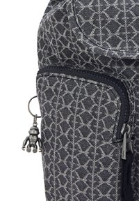 Textilní batoh v tmavě šedé barvě s geometrickým vzorem. Obsahuje zipovou kapsu a malý kovový přívěsek připevněný k táhlu zipu.