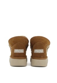 Twee bruine suède enkelboots met geweven textielaccenten, voorzien van een beige rubberen zool en een zichtbaar logo-label achterop.