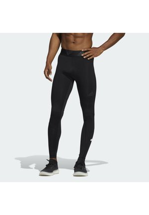 Czarne legginsy sportowe o gładkiej fakturze, z dopasowanym krojem, wysokim stanem i małym logo na górnej części uda.