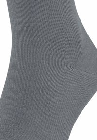 Graue Socke mit geripptem Muster, die eine glatte Oberfläche und ein tailliertes Design aufweist. Das Material ist weich und sorgt für einen bequemen Sitz.