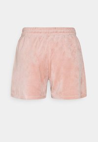 Shorts en velours rose avec une taille élastique, présentant une texture douce et un design simple. Pas de poches ni d'ornements.