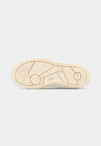 Sneakersula i beige gummi med texturerade greppmönster och en cirkulär akcent. Har "Polo"-märke nära hälen.