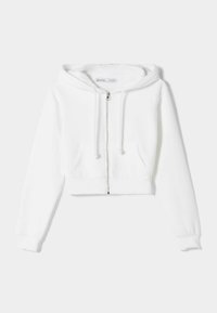 Felpa bianca corta con zip frontale, cappuccio regolabile con coulisse e due aperture per le tasche, esposta su uno sfondo semplice chiaro.