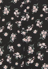 Tessuto nero con un motivo floreale che presenta fiori rosa e bianchi. Bottoni centrati neri con una finitura liscia e una superficie texturizzata.