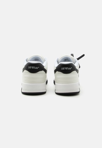 Ζευγάρι λευκά και μαύρα παπούτσια Off-White, εμφανιζόμενα από πίσω, με μέγεθος "31" μέσα στους επενδυμένους γιακάδες.