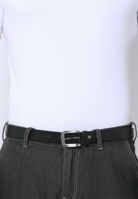 Zwarte leren riem met een zilveren gesp gedragen op donkergrijze broeken en een gestreken wit shirt.