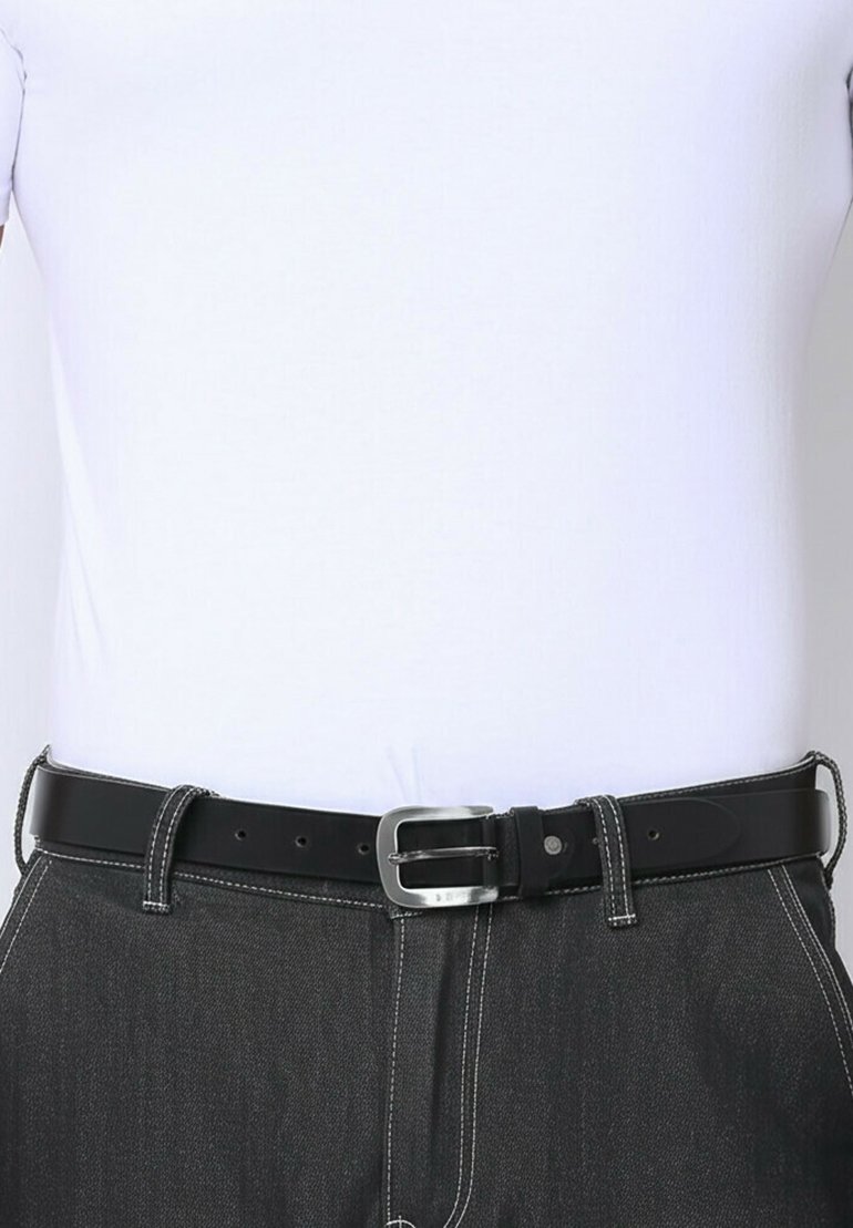 Zwarte leren riem met een zilveren gesp gedragen op donkergrijze broeken en een gestreken wit shirt.