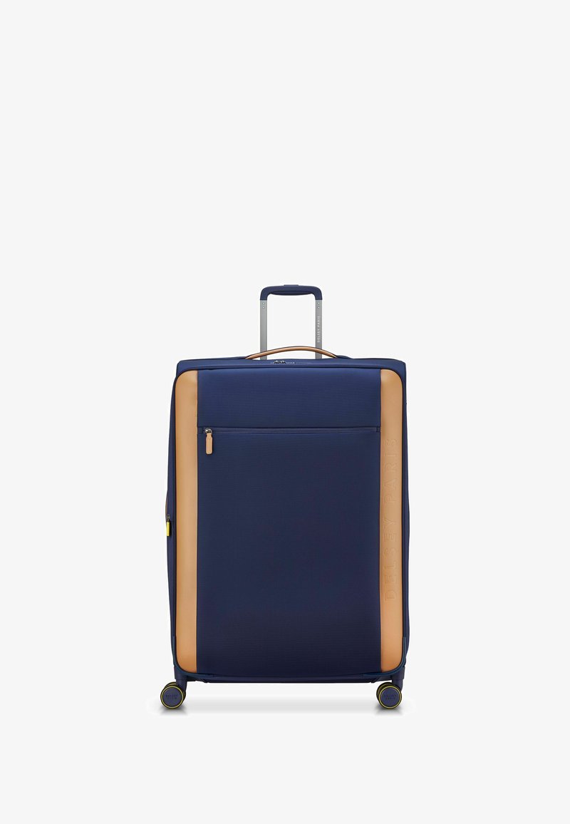 Valigia blu navy con esterno texturizzato, pannello di accento beige, tasca frontale con zip, manico retraibile e quattro ruote con dettagli gialli.