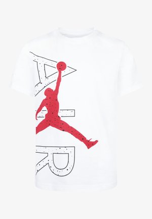 Biały T-shirt z dużą czerwoną sylwetką koszykarza skaczącego z piłką oraz czarnym nakrapianym, częściowo widocznym napisem "AIR".