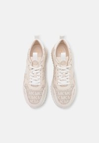 Vaaleat lenkkarit, joissa on sileä nahkapinta ja teksturoitu kangas, johon on painettu koko pinnan kattava logomalli. Valkoiset nauhat ja kumipohja.