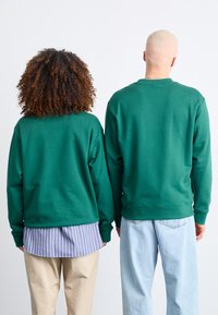 New Balance GRAPHIC CREW UNISEX - Felpa - nightwatch green