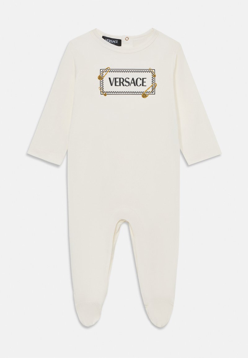Bebina bodi u krem boji od mekog materijala, s dugim rukavima, okruglim izrezom i ispisom crnog i zlatnog "VERSACE" loga.