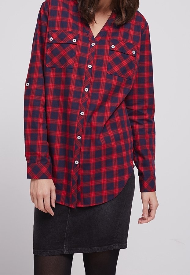 Rood en marineblauw geruit shirt met lange mouwen, twee borstzakken en witte knopen. Gecombineerd met een zwarte denim rok.