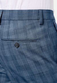 Texturerade blå rutiga byxor med en knappad bakficka, rak framsida och skräddarsydd passform med en strukturerad midjeband.