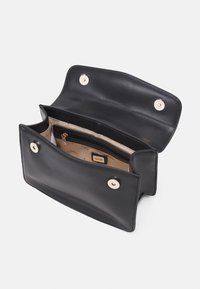 Borsa in pelle nera con texture liscia, pattina superiore e bottoni a pressione dorati. L'interno presenta una tasca con zip e una fodera di colore chiaro.