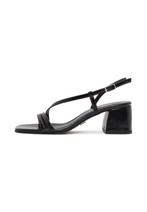 Sandal con tacco in pelle nera caratterizzata da due cinturini anteriori, chiusura a fibbia e design con punta quadrata e tacco a blocco. Texture liscia.