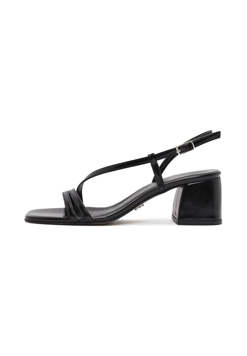 Sandal con tacco in pelle nera caratterizzata da due cinturini anteriori, chiusura a fibbia e design con punta quadrata e tacco a blocco. Texture liscia.
