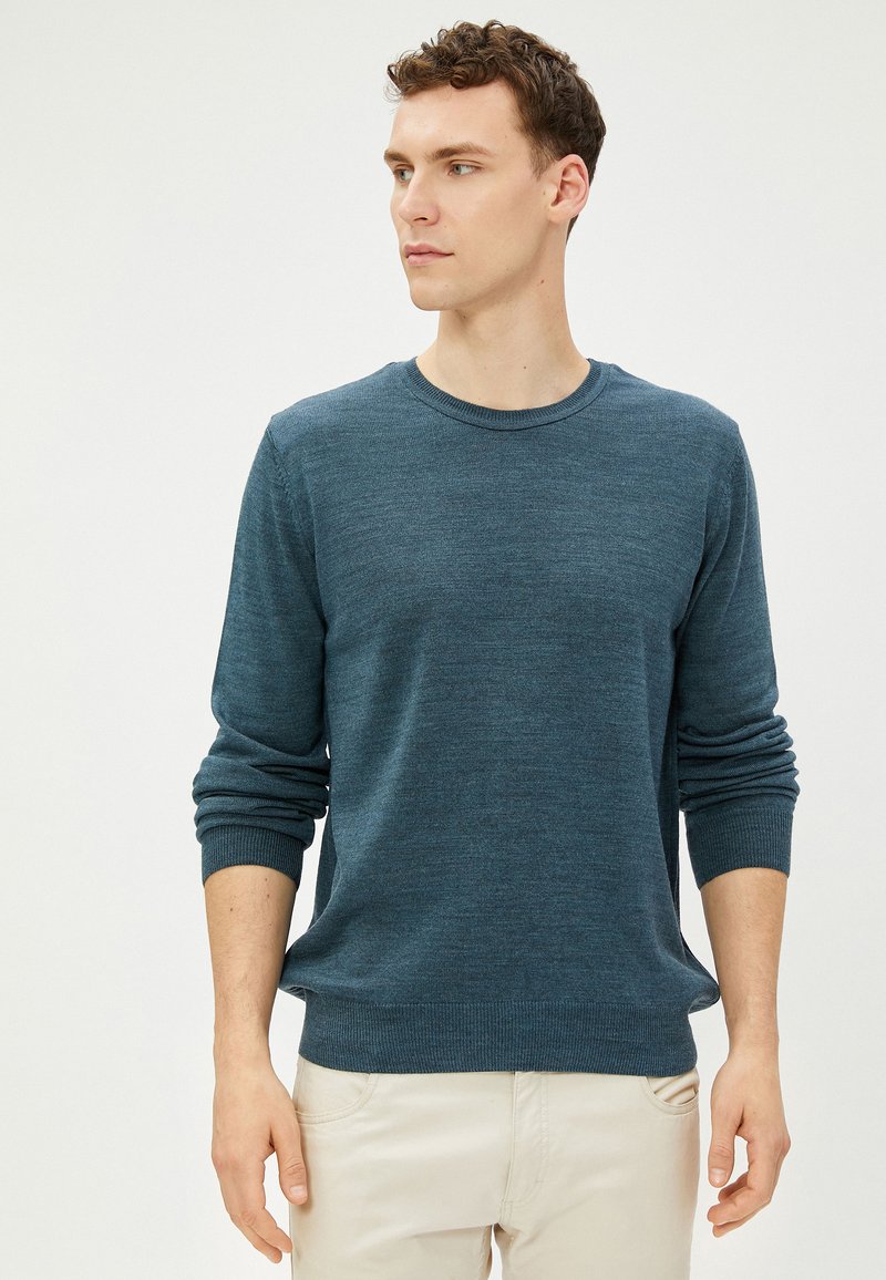 Dunkelblauer Pullover für Herren aus weichem Strickstoff, Rundhalsausschnitt, lange Ärmel, gerippte Bündchen und Saum, mit glatter Textur und lässiger Passform.