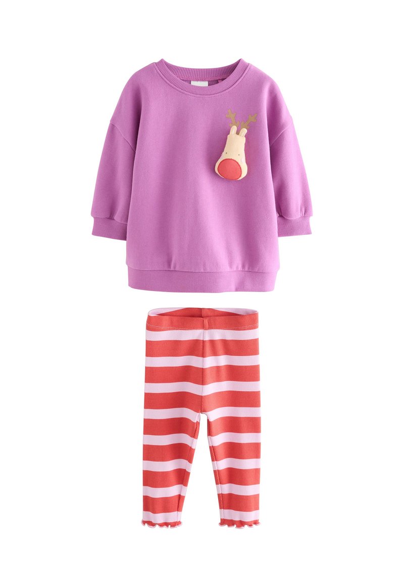 Paarse trui met een rendierapplicatie op de borst, gecombineerd met rood-wit gestreepte legging met een geschulpte zoom bij de enkels.