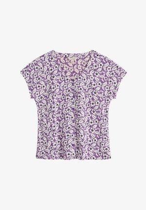 Purpurs krshorta piedurkņu blūze ar baltiem un melniem ziedu rakstiem, ar V veida kakla izgriezumu un izsmalcinātām pogu detaļām.