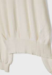 Maglione beige chiaro con texture a coste, spalle cadenti e dettaglio arricciato all'orlo. Tessuto morbido con vestibilità comoda.