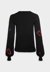 Musta neule, jossa on pitkät hihat ja joissa on brodeerattuja punaisia sydämiä, sininen yksityiskohta ja hienovaraiset yksityiskohdat molemmissa hihoissa. Pehmeä, tekstuuri materiaali.