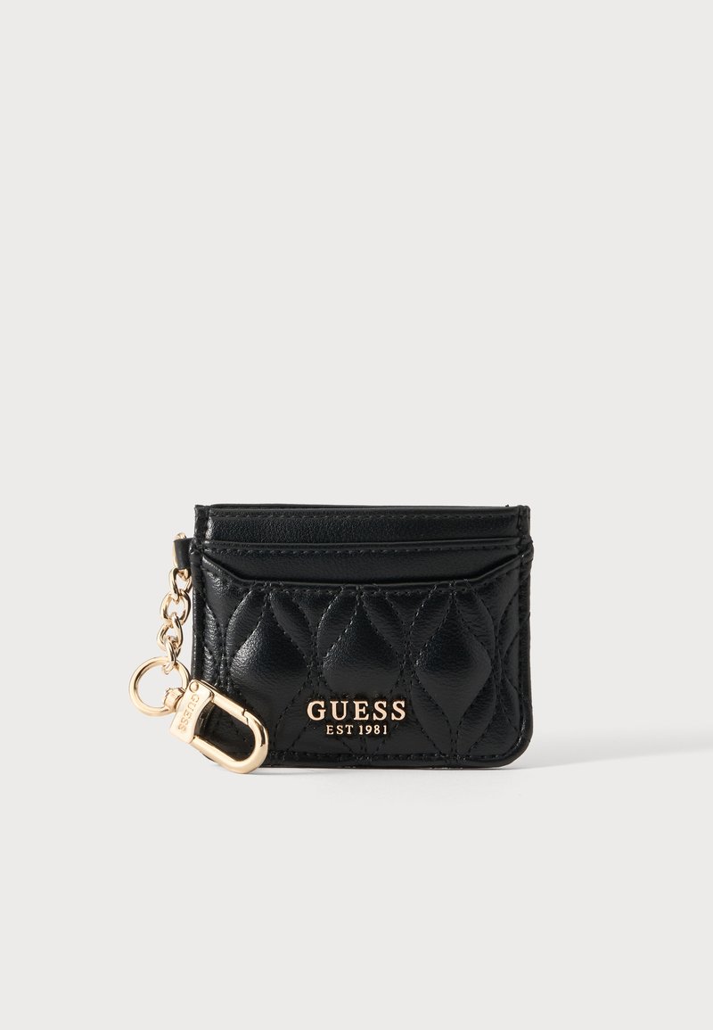 Porte-cartes en cuir matelassé noir Guess avec logo doré et clip porte-clés doré attaché sur un fond clair uni.