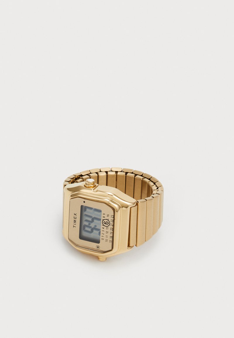 Montre numérique dorée avec un cadran rectangulaire, attachée à un bracelet à maillons flexibles. Dotée d'un écran numérique clair et d'un bouton simple sur le côté.