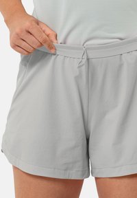 Lichtgrijze shorts met een elastische tailleband en trekkoord. Voorzien van een zachte, lichte stof; een gladde textuur; en zijzakken.