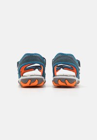 Blå og grå sandal med justerbare stropper, hvit såle og oransje detaljer. Har en teksturert hæl og forsterkede sømmer.