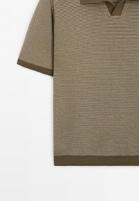 Short-sleeve, knit polo shirt with textured horizontal stripes in beige and olive green, featuring ribbed cuffs and hem.