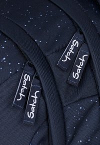 Schwarzer Nylon-Rucksack mit strukturiertem Oberflächen, der weiße Sprenkel aufweist und zwei Reißverschlusszüge mit der Aufschrift "Satch" hat.