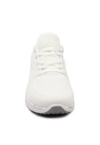 Sneaker bianca da atletica con tomaia in mesh traspirante, allacciatura tradizionale, suola imbottita e un sottile motivo testurizzato sulla suola.