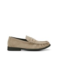Beige suède instappers met een zwarte platte zool, voorzien van een gestikte moccasin teen en een decoratieve vampband.
