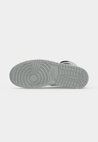 Σόλα γκρι αθλητικού παπουτσιού Nike με κυκλικά και δικτυωτά σχέδια πέλματος και το λογότυπο Nike χαραγμένο στο κέντρο.