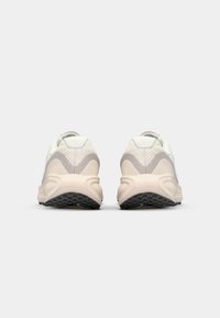 Witte en beige sneakers met een gestructureerde mesh bovenkant, gevoerde kraag en duurzame rubberen zool met grippatronen.