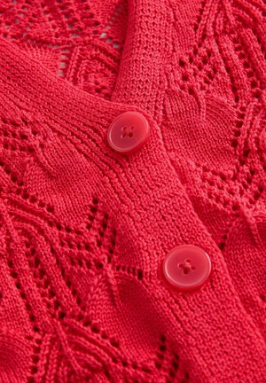 Roter, gestrickter Cardigan mit einem Spitzenmuster, V-Ausschnitt und zwei glänzenden roten Knöpfen. Die Textur ist detailliert und fein mit offenen Maschen.