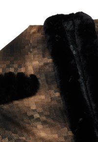 Brun mönstrad sjal med en mjuk svart pälskrage och detaljer. Har en pixeliserad design och en slät textur genom hela sjalen.