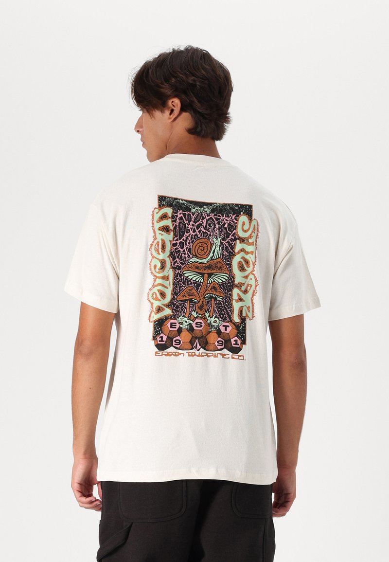 Camiseta de algodón crema con un colorido estampado gráfico en la parte posterior, que incluye setas, un caracol y elementos de texto. Manga corta, corte relajado.
